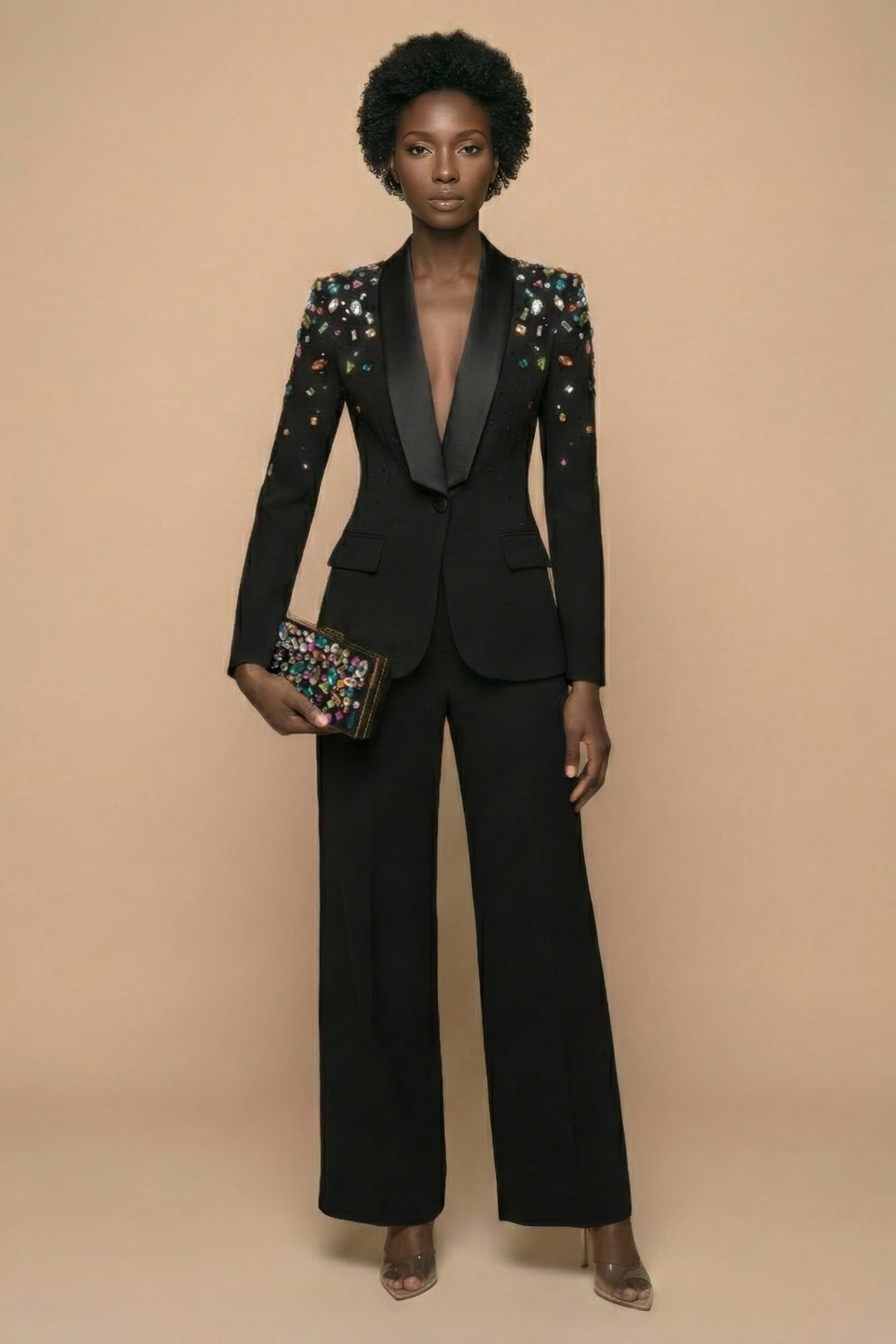 Woman wearing a black suit with floral embellishments on a beige background