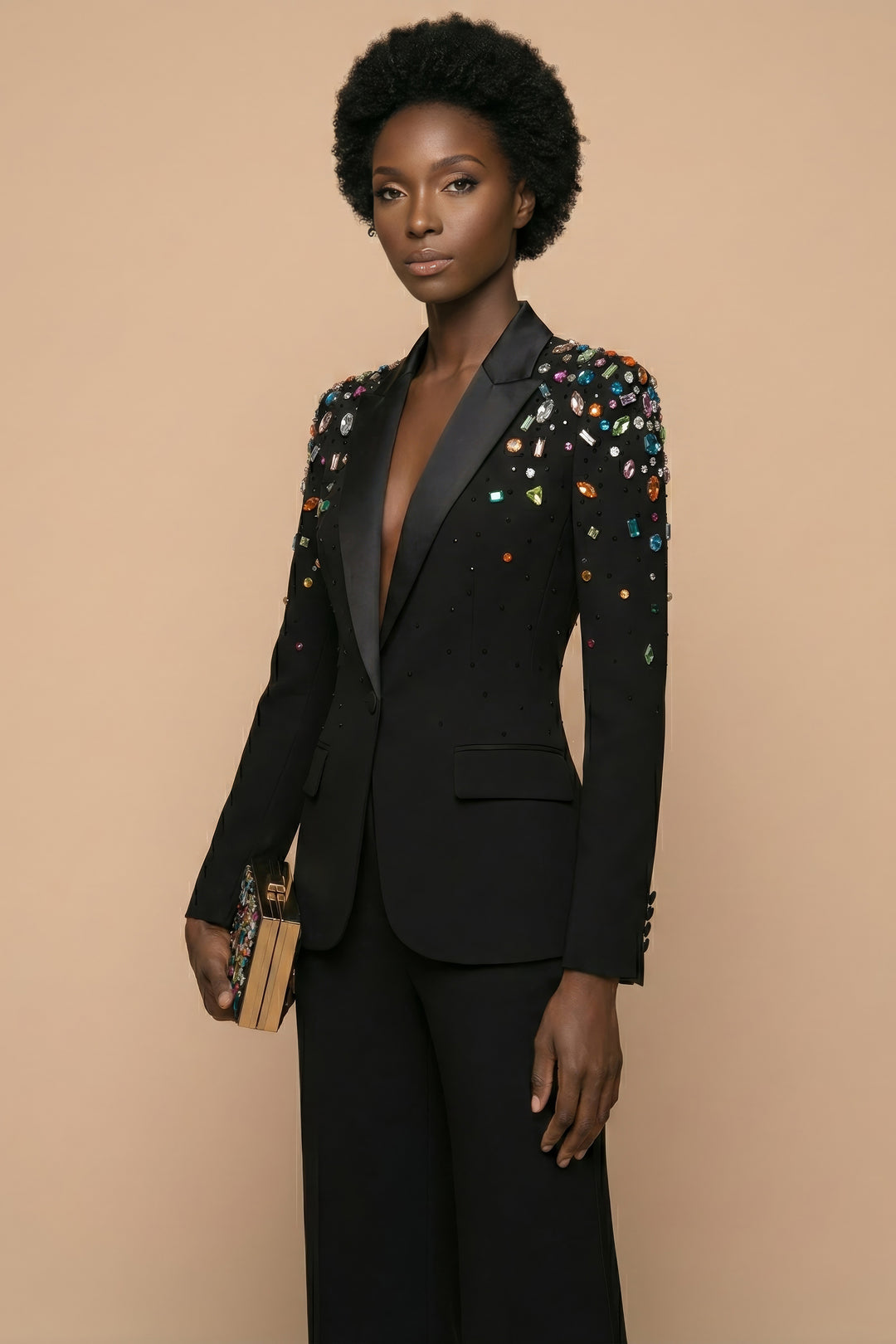 Woman wearing a black suit with colorful embellishments on a beige background