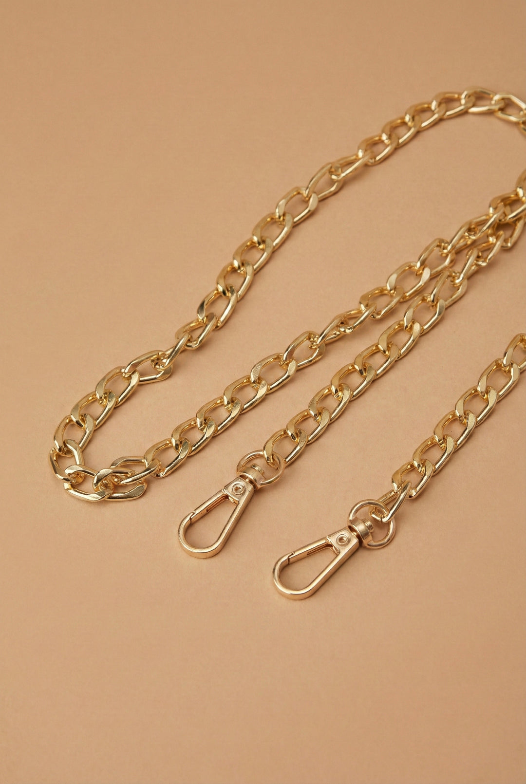 Gold chain with clasp on a beige background